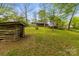 Discover the backyard featuring a convenient log shed, offering both storage and rustic charm amidst the lush greenery at 2106 4Th Ne St, Hickory, NC 28601