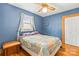 Cozy bedroom with a charming quilt-covered bed, complemented by blue walls and natural light from the window at 2106 4Th Ne St, Hickory, NC 28601