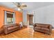 Living room with hardwood floors, an orange accent wall, and two brown leather sofas at 2106 4Th Ne St, Hickory, NC 28601