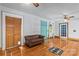 Living room with hardwood floors, a brown leather sofa, and a bright teal front door at 2106 4Th Ne St, Hickory, NC 28601