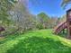 Lush green backyard with well-maintained lawn, mature trees, and a staircase, perfect for outdoor activities and relaxation at 213 Walnut Point Dr, Matthews, NC 28105
