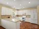 Well-lit kitchen with white cabinetry, modern appliances, and hardwood floors at 213 Walnut Point Dr, Matthews, NC 28105