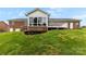 A brick house shows a sunroom, a generator, a small brick retaining wall, and a tiered deck in the backyard at 2459 Glenridge Dr, Gastonia, NC 28054
