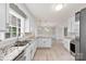Bright, open kitchen featuring white cabinets, granite countertops, stainless steel appliances and plank flooring at 2459 Glenridge Dr, Gastonia, NC 28054
