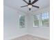 Bright bedroom featuring two windows with white trim, neutral carpet, and a ceiling fan with light at 2729 Clemson Ave, Charlotte, NC 28205