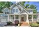 Charming two-story home boasts a welcoming front porch, complemented by mature trees and manicured landscaping at 2729 Clemson Ave, Charlotte, NC 28205