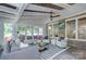 Bright sunroom features a beamed ceiling, large windows, and comfortable seating arrangements at 2729 Clemson Ave, Charlotte, NC 28205