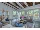 Bright sunroom features a beamed ceiling, large windows, and comfortable seating arrangements at 2729 Clemson Ave, Charlotte, NC 28205