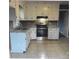 Functional kitchen featuring white cabinets, stainless steel appliances, and neutral tile flooring at 2831 Denview Ln, Charlotte, NC 28208