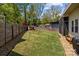 A huge backyard with a shed, a new fence, and a line of river rock bordering the lawn at 3036 Palm Ave, Charlotte, NC 28205