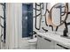 Modern bathroom features navy tiled shower, unique wall art, and sleek vanity at 3036 Palm Ave, Charlotte, NC 28205
