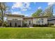 Charming single-story home featuring well-manicured lawn, modern design, and inviting front entrance with gray accents at 3036 Palm Ave, Charlotte, NC 28205