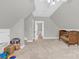 Large finished attic with a crib, carpeted floor, and natural light from an open doorway at 3068 Green Acres Ln, Claremont, NC 28610