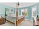 Inviting bedroom featuring a four-poster bed, two large windows, and light blue walls at 3068 Green Acres Ln, Claremont, NC 28610