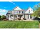 Charming two-story home featuring a welcoming front porch and well-manicured lawn on a sunny day at 3068 Green Acres Ln, Claremont, NC 28610
