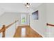 Upstairs hallway features hardwood floors and natural light from the window at 3068 Green Acres Ln, Claremont, NC 28610