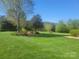 A well-manicured lawn and shade trees provide a beautiful green space on this property at 3068 Green Acres Ln, Claremont, NC 28610