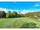 A spacious yard with well-maintained lawn and mature trees provide a stunning backdrop to this property at 3068 Green Acres Ln, Claremont, NC 28610