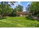 Expansive backyard with lush lawn, mature trees, a covered patio, and manicured landscaping, ideal for outdoor enjoyment at 311 Mcalway Rd, Charlotte, NC 28211