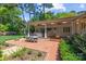 Picturesque backyard with a covered patio, outdoor dining area, lush greenery, and well-maintained landscaping at 311 Mcalway Rd, Charlotte, NC 28211