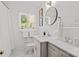 Cozy bathroom featuring marble countertop, round mirror, neutral accents and a garden view at 311 Mcalway Rd, Charlotte, NC 28211