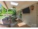 Relaxing covered patio with brick flooring, a ceiling fan, TV, and comfortable seating perfect for outdoor entertainment at 311 Mcalway Rd, Charlotte, NC 28211