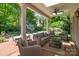 Inviting covered patio with brick flooring, a ceiling fan, comfortable seating, and view of the manicured backyard at 311 Mcalway Rd, Charlotte, NC 28211
