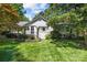 Charming brick home with a beautifully landscaped front yard and mature trees under a blue sky at 311 Mcalway Rd, Charlotte, NC 28211