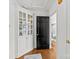 Hallway featuring hardwood floors, built-in shelving, black door, and view into the living room at 311 Mcalway Rd, Charlotte, NC 28211