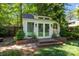 Charming backyard studio with large windows, brick accents, and a private entrance surrounded by lush greenery at 311 Mcalway Rd, Charlotte, NC 28211