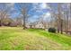 Spacious backyard featuring a green lawn, mature trees, and a view of the home's exterior at 32 Heritage Ln, Shelby, NC 28150