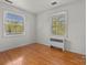 A bright room has hardwood flooring and plenty of light from the two large windows, creating a comfortable space at 343 Wakefield Dr # C, Charlotte, NC 28209