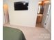 A modern bedroom has beige carpet, neutral paint and a television mounted on the wall at 346 Cornielle Ln, Charlotte, NC 28216