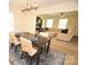 Open dining area with modern chandelier, dark wood table, seating for six, and a seamless transition to the living room at 346 Cornielle Ln, Charlotte, NC 28216
