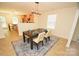Dining area with modern lighting fixture, dark wood table, seating for six, and seamless transition to the kitchen at 346 Cornielle Ln, Charlotte, NC 28216