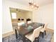 Bright dining room with modern chandelier, dark wood table, seating for six, and a seamless transition to the living room at 346 Cornielle Ln, Charlotte, NC 28216