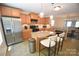 Well-lit kitchen featuring stainless steel appliances, granite countertops, kitchen island, and an open view to the dining area at 346 Cornielle Ln, Charlotte, NC 28216