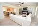 Open-concept living room with plush carpeting, modern fireplace, and seamless flow to the dining area at 346 Cornielle Ln, Charlotte, NC 28216