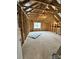 Unfinished attic space showing exposed wooden beams and natural light from a window at 4038 Gardenia Dr # 0114, Harrisburg, NC 28075
