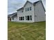 New construction showing the backyard and rear exterior with expansive windows and a well-manicured lawn at 4038 Gardenia Dr # 0114, Harrisburg, NC 28075