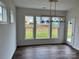 Bright dining room with backyard view and elegant modern lighting fixture at 4038 Gardenia Dr # 0114, Harrisburg, NC 28075
