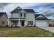 Charming two-story home with a gray exterior, a well-manicured lawn and an attached two car garage at 4038 Gardenia Dr # 0114, Harrisburg, NC 28075