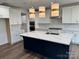 Modern kitchen features a large center island, white cabinets, stainless steel appliances, and designer lighting at 4038 Gardenia Dr # 0114, Harrisburg, NC 28075