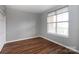 This bedroom features wood floors, neutral gray walls, a closet and a large window with coverings at 405 W 7Th St # 408, Charlotte, NC 28202
