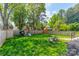 Spacious fenced backyard featuring lush lawn, playground set, and comfortable Adirondack chairs at 410 Mcalway Rd, Charlotte, NC 28211