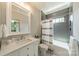 Bathroom featuring a vanity with marble countertops and a shower-tub combo with modern gray tiling and a shower curtain at 410 Mcalway Rd, Charlotte, NC 28211