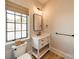 Half bathroom features white vanity and a black framed mirror next to a window at 410 Mcalway Rd, Charlotte, NC 28211