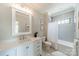 A bright bathroom features white cabinets, updated fixtures, and a shower with gray tile at 410 Mcalway Rd, Charlotte, NC 28211