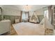 A Bedroom with light green paneled walls, neutral carpet, and elegant light fixture at 410 Mcalway Rd, Charlotte, NC 28211
