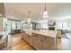 Bright, open kitchen with a large island, farm sink, and modern lighting flowing into the dining and living areas at 410 Mcalway Rd, Charlotte, NC 28211